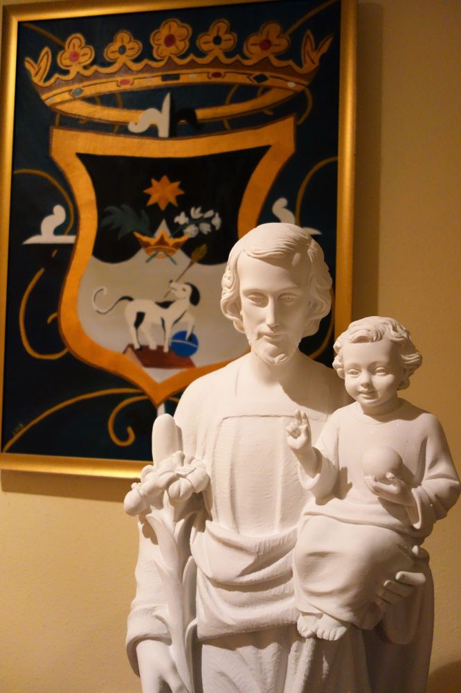 Statue de Saint Joseph devant le blason dominicain dans le hall d'entrée de l'école.